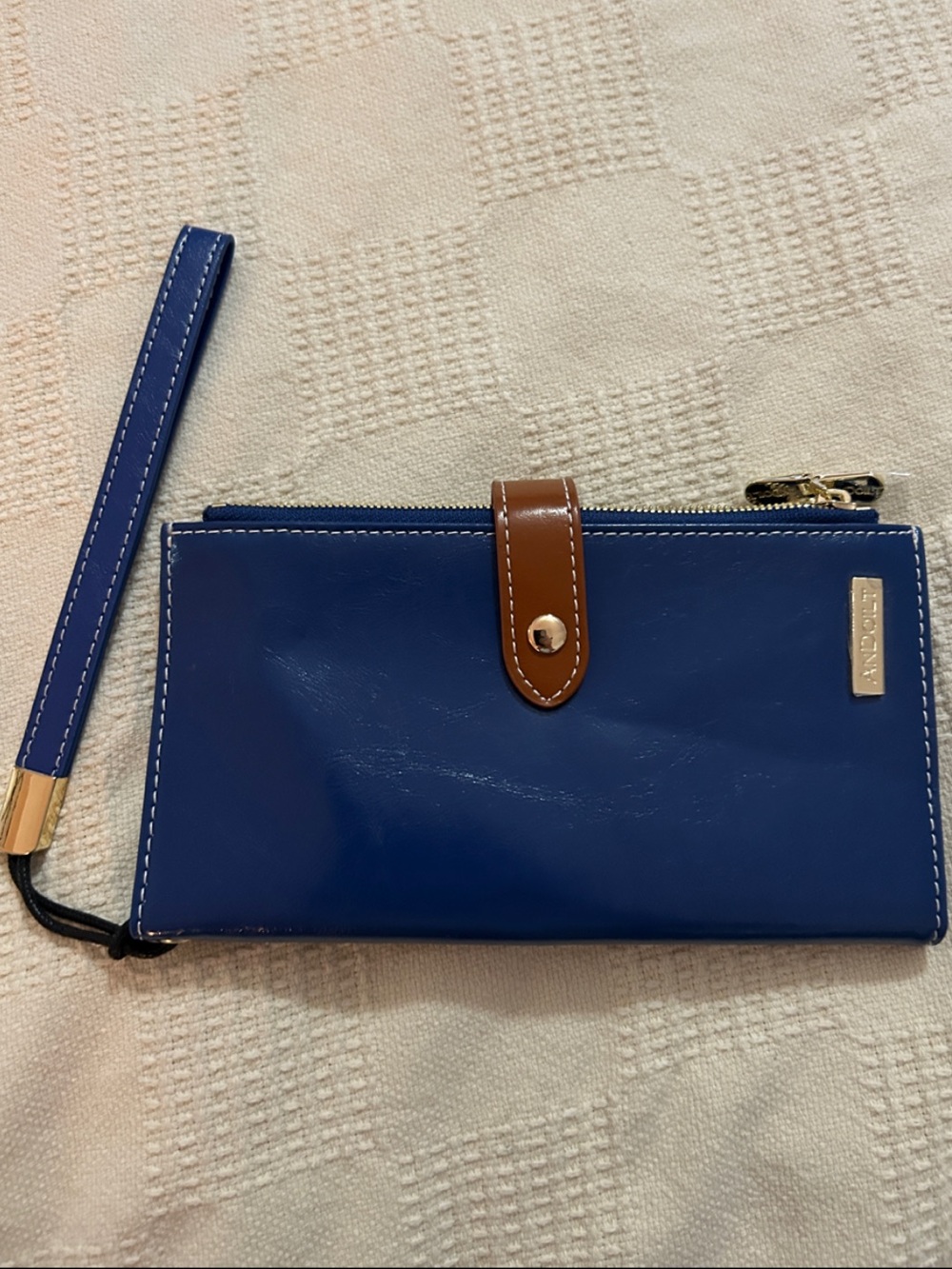 ANDOILT RFID-blocking wristlet wallet distinguished by a contrasting brown snap